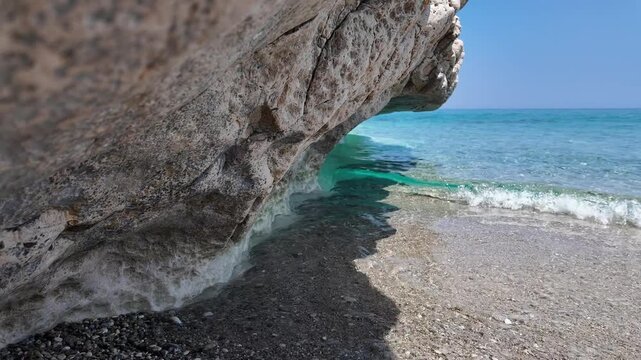 Seaside rock formation with gentle waves below. Ideal for nature and travel backgrounds.