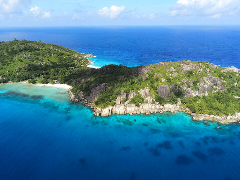 Aerial view of Grande Soeur island featuring granite cliffs, lush tropical forests, and turquoise waters La Digue, Seychelles.