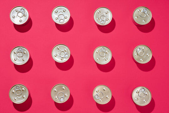 Pattern of metal tin cans on pink background