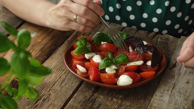 Woman eating caprese salad. Vegetarian italian cuisine. Healthy diet, tasty dinner.