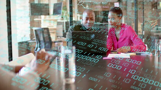 Two colleagues using laptop, foreground hand tapping tablet and starting data overlay for business