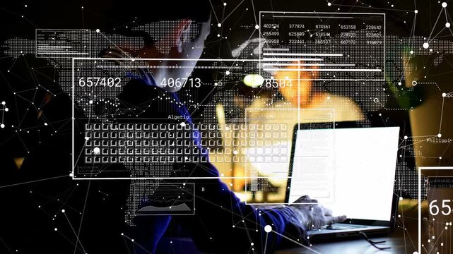 Man typing on laptop in dim workspace, causing HUD overlaying hands and updating data analytics