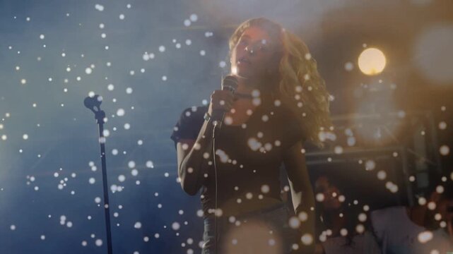 Lead singer gripping mic, whipping hair to music, settling into pose with guitar, lights, particles