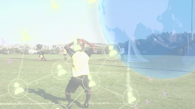Male soccer player kicking ball at goal, creating attack as transparent globe and nodes overlaying