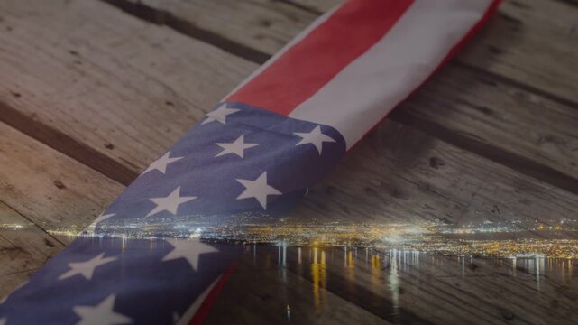 Camera pulling back along folded US flag for memorial film, city lights overlay staying fixed