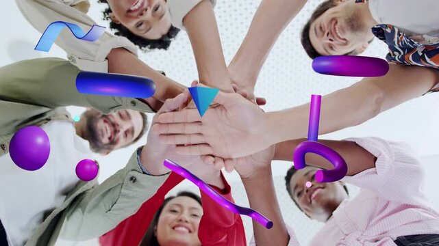 Team members leaning in, stacking hands showing teamwork in business, purple 3D shapes obscuring