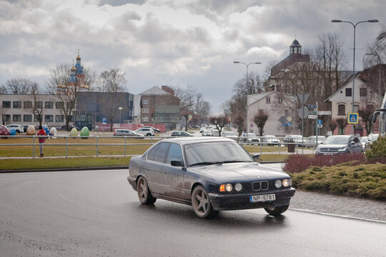 Bauska, Latvia, April 7, 2026: A roundabout at the entrance to the city of Bauska, with a BMW car driving along the road in the foreground