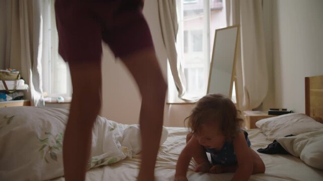 Young siblings playing on bed jumping up and down with dynamic movement showing joy energy and authentic bonding moment during playful indoor family time