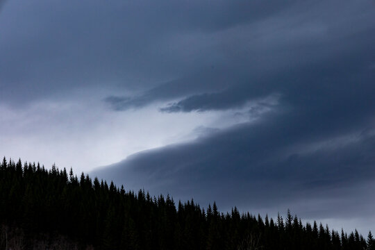 A dramatic landscape with dark clouds in the evening sky over Norddal village. An early spring scenery of Norway, UNESCO world heritage site.