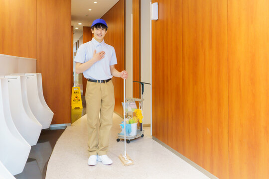 オフィスビルのトイレに立つ若い日本人男性清掃員　撮影協力：学校法人電波学園 東京電子専門学校