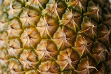 Fototapeta premium Close-up view of a pineapple's textured skin showing detailed scales and natural patterns