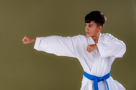 Side view of a young karate student executing a punch with proper alignment, demonstrating strength and technique.