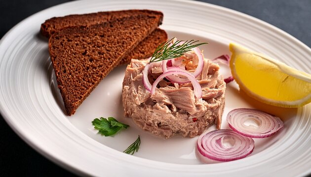 tuna stroganina with pickled onion lemon wedge and rye bread on a white plate fresh seafood for gourmet dining top view