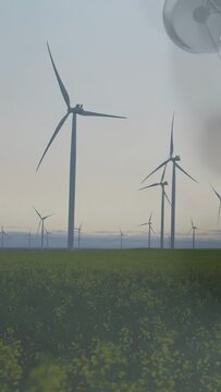 Vertical video: Wind turbine being overlapped as clear orb drifting in, deploying tethers to anchor