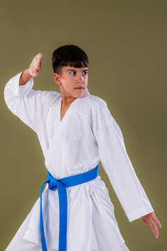 Young karate practitioner holds a defensive stance with an upper block, demonstrating awareness, focus, and proper Shotokan technique.