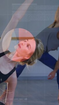 Vertical video: Coach cuing woman in fitness side-bending for mobility by barre HUD charts aligning