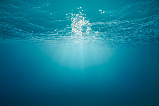 Sunlight Rays Underwater Surface, Clear Blue Ocean Background with Light Reflections
