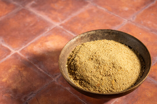 Nutritional Yeast in a wood bowl on a tile surface 