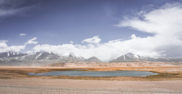 Mountain landscape with a view of a rocky mountain ridge with snow and glaciers in the highlands of Tajikistan in the Pamirs. A panorama of the Tien Shan Mountains for background