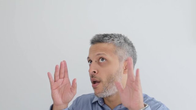 Shocked mature man making exaggerated mind blown gestures against white background