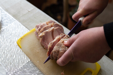 Obraz premium Woman cutting ham on the table. Selective focus.