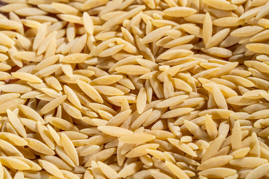 Close up of uncooked orzo pasta on a tile surface 