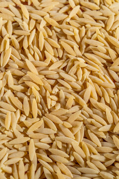 Close up of uncooked orzo pasta on a tile surface 