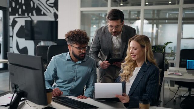 Three diversity managers business team talking look at diagram statistic income growth in papers Caucasian boss businessman pointing in documents talk with workers typing digital tablet in office