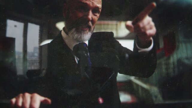 Annoyed male politician delivering a fierce speech on retro TV set screen