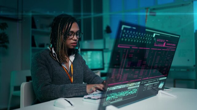 Young female developer typing complex programming code on holographic display