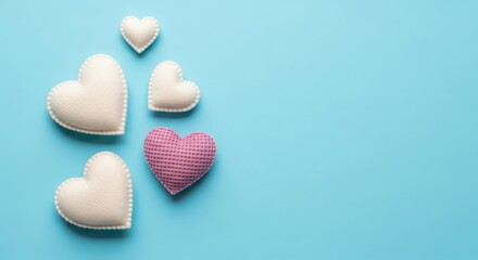 Obraz premium Decorative fabric hearts on blue background, soft textile heart shapes for Valentine's Day, romantic craft ornaments with copy space for greeting cards