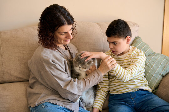 Mother and son with cerebral palsy enjoying pet therapy at home