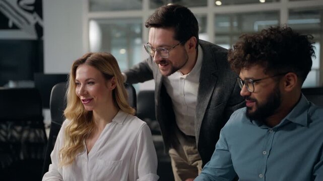 Three happy multiethnic business colleagues looking in laptop celebrating achievement triumph giving high five cheering applause diversity coworkers talking winning with computer win team in office