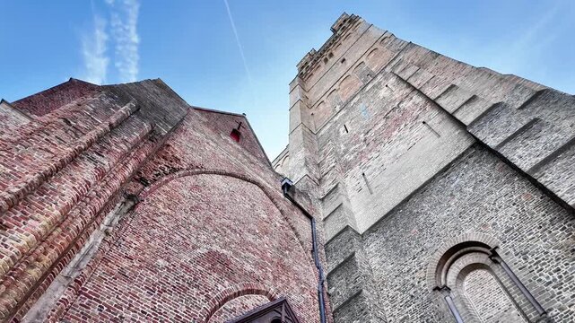 Wide shot of a historic red brick house with white gables in the Flanders countryside.