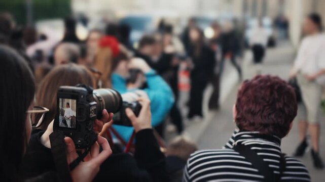 Photographers taking pictures of a model during fashion week