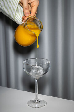 A hand pours juice into a glass