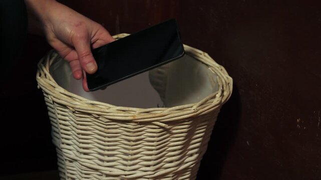 Hands putting mobile phone in the bin