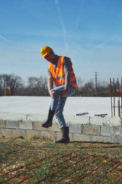 Construction worker having a accident and injured knee and leg on a construction site outdoors.