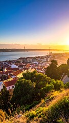 Obraz premium Aerial view of a city during sunset, highlighting red-tiled roofs, a river, and distant bridge with a clear blue sky