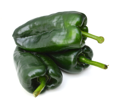 Stack dark green poblano peppers isolated on white