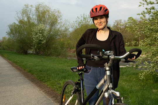 Female cyclist standing with her bike, adjusting seat height for comfortable ride