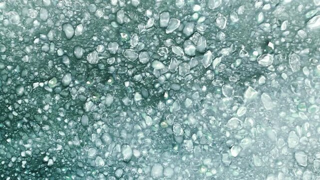 Aerial view of frozen sea with floating ice floes and slush.