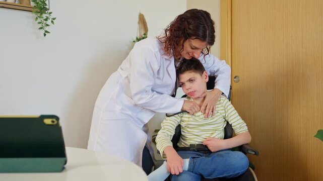 Female pediatrician examining boy with cerebral palsy at home