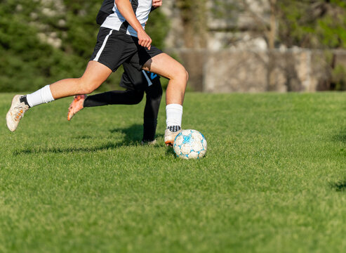 Two Soccer Players Competing for Ball on Grass Field