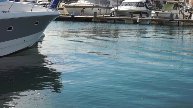 Boats are tied at the dock near calm water