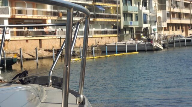 Boats are tied to docks next to buildings. Empuriabrava, Spain