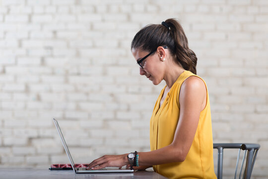 Young Arab woman working on laptop in a creative startup coworking office space
