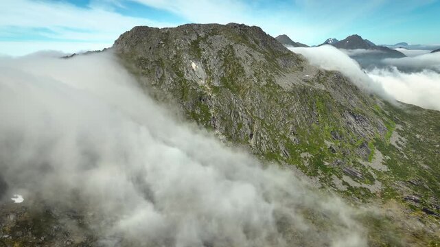 Aerial of of the clouds flowing over a mountain in Norway