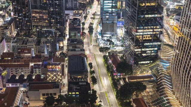 Looking down at the tall buildings along a busy road at night in Singapore.