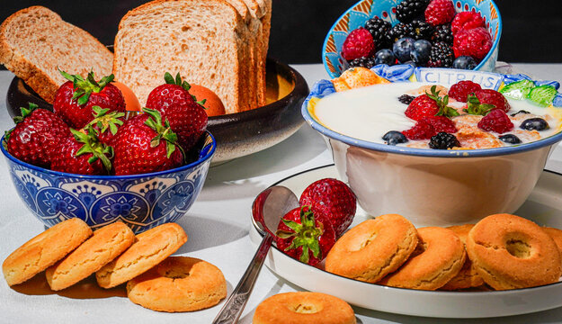 Colazione vegana. Still life di food con latte yogourt biscotti fragole frutti rossi  uova e pane, rappresentazione di colazioneme diterranea a base di alimenti sani